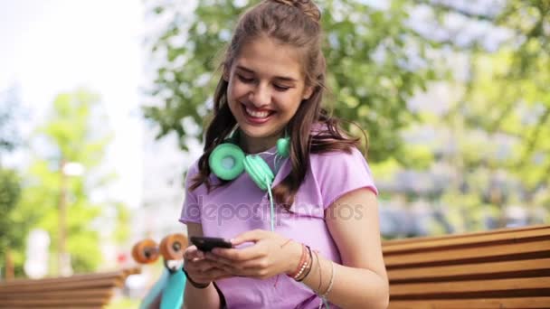 Счастливая девочка-подросток со смартфоном и лонгбордом — стоковое видео