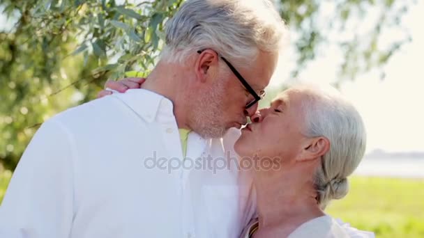Щаслива старша пара цілується в літньому парку — стокове відео