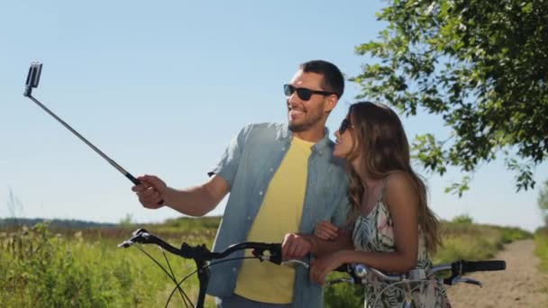 Pareja con bicicleta y smartphone selfie stick — Vídeo de stock