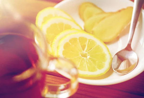 Cangkir teh dengan lemon dan jahe di piring — Stok Foto
