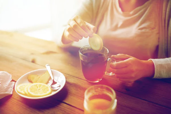 Primo piano della donna che aggiunge limone alla tazza di tè — Foto Stock