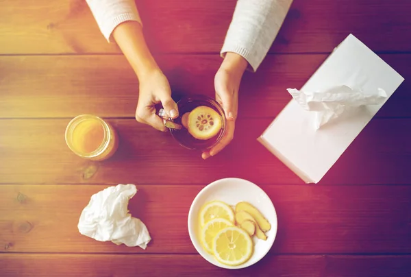 Хвора жінка п'є чай з лимоном та імбиром — стокове фото