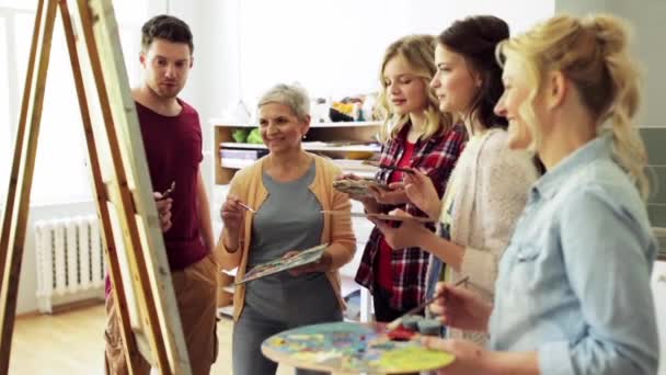 Groep kunstenaars schilderkunst aan de kunstacademie te bespreken — Stockvideo