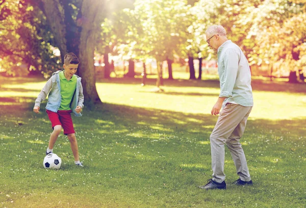 Viejo hombre y niño jugando al fútbol en el parque de verano — Foto de Stock