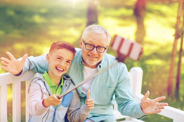 Old man and boy taking selfie by smartphone — Stock Photo, Image