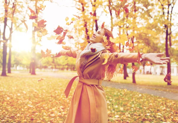 Femme heureuse s'amuser avec des feuilles dans le parc d'automne — Photo