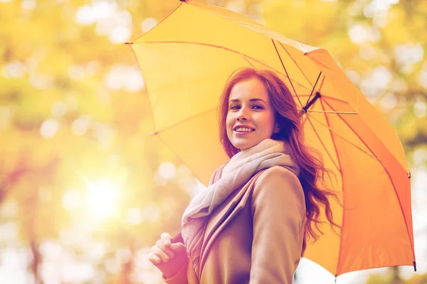 Donna felice con ombrellone passeggiando nel parco autunnale — Foto Stock