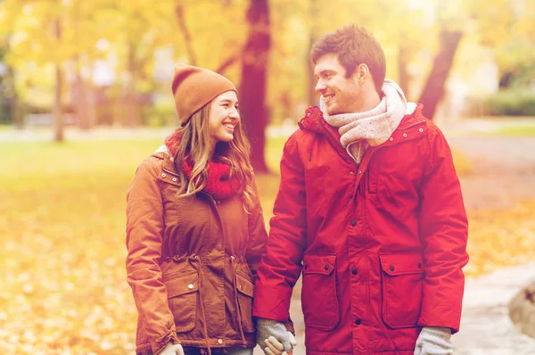 Happy young couple walking in autumn park — Stock Photo, Image