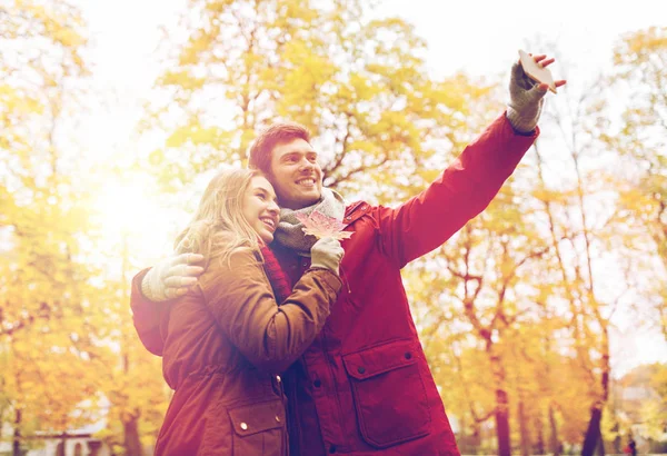 Pareja tomando selfie por smartphone en el parque de otoño — Foto de Stock