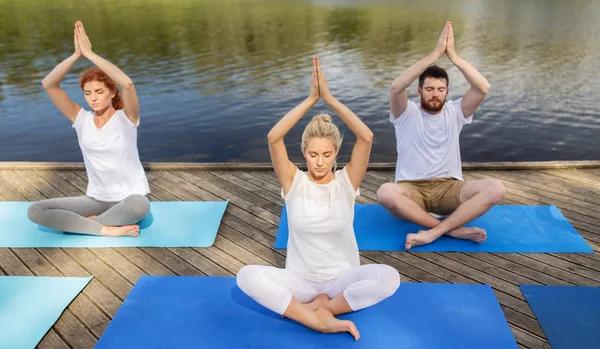 Люди медитують в йозі лотос позують на відкритому повітрі — стокове фото