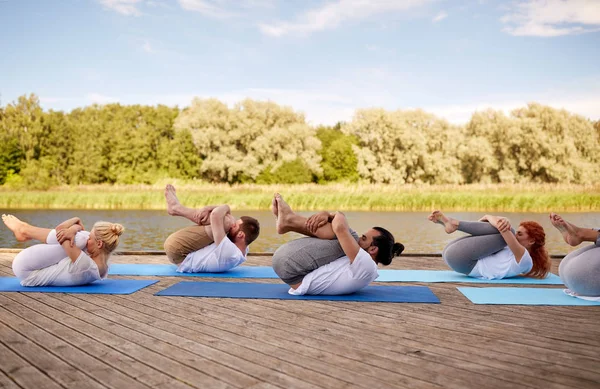 Grupo de personas haciendo ejercicios de yoga al aire libre —  Fotos de Stock