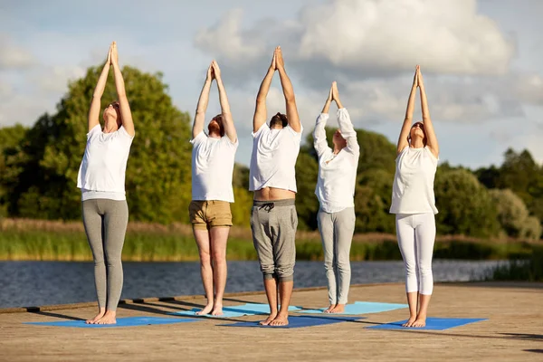 Groep mensen die buiten yoga oefeningen doen — Stockfoto