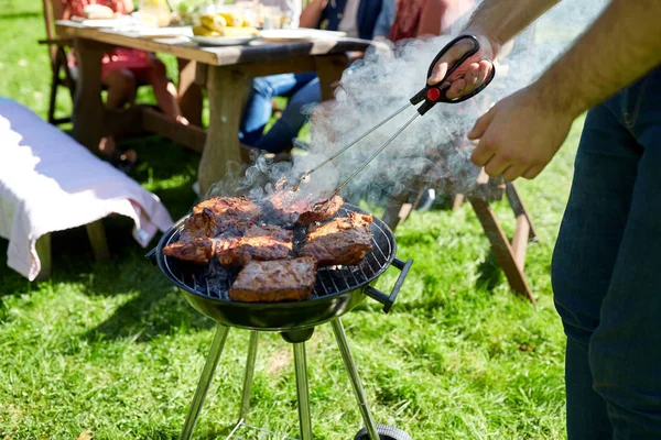 여름 파티에 바베 큐 그릴에 고기를 요리 하는 남자 — 스톡 사진