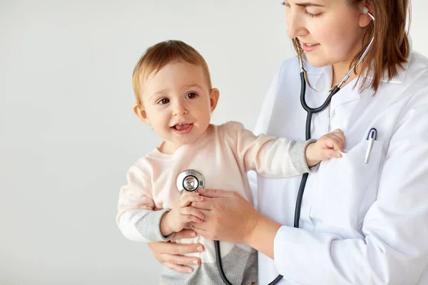 Arts met de stethoscoop luisteren baby bij kliniek — Stockfoto