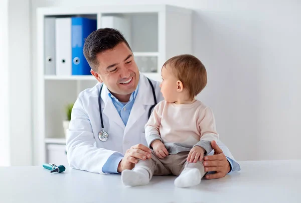 Lykkelig lege eller barnelege med spedbarn på klinikken – stockfoto
