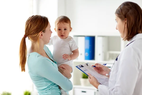 Mulher feliz com bebê e médico na clínica — Fotografia de Stock