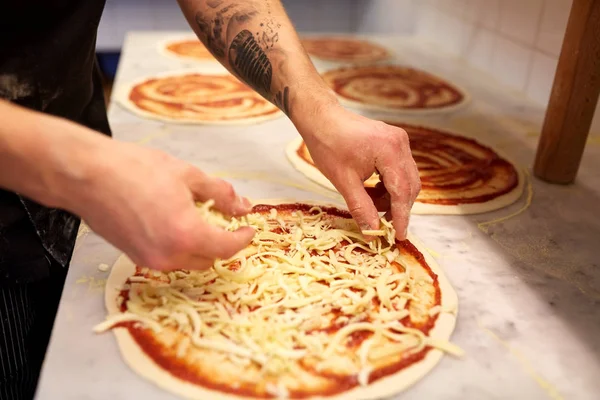Yemek rendelenmiş peynir pizza pizzacı, ekleme — Stok fotoğraf