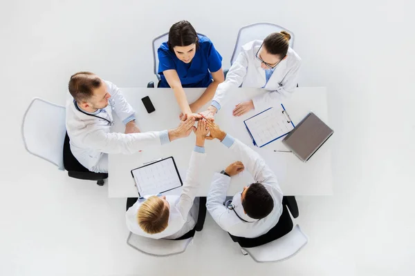 Groupe de médecins faisant haut cinq à la table — Photo