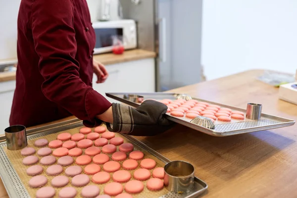 Chef with macarons on oven tray at confectionery — Stock Photo, Image