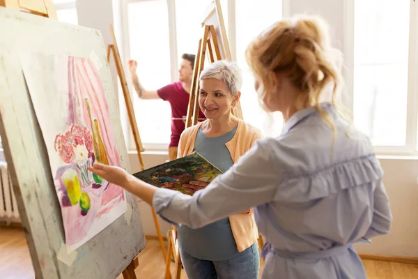 Künstler diskutieren in Kunstschule über Malerei auf Staffelei — Stockfoto