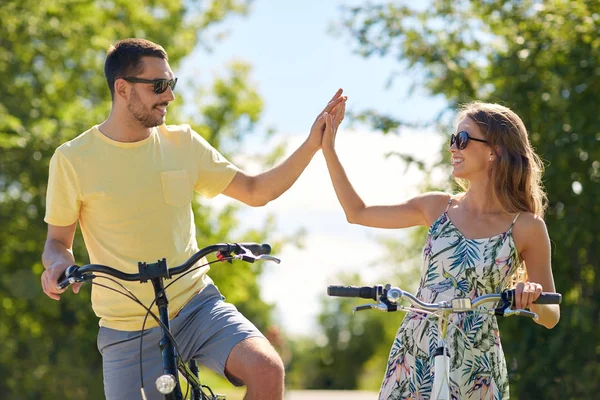 Счастливая пара с велосипедами, которые дают пять — стоковое фото