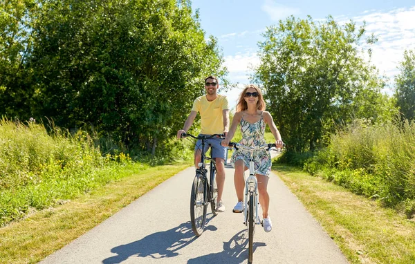 Happy young couple riding bicycles in summer — Stock Photo, Image