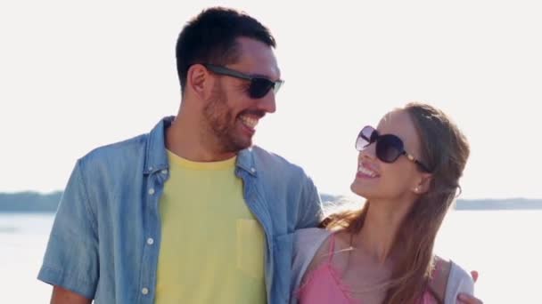 Happy couple in sunglasses hugging over sea — Stock Video
