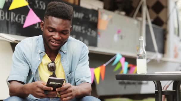 Hombre afroamericano con smartphone en camión de comida — Vídeos de Stock