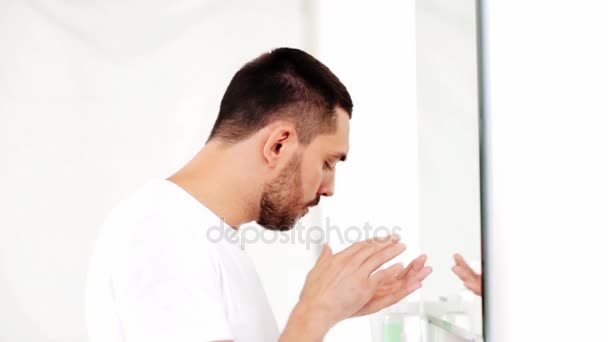 Man applying after shave oil to face at bathroom — Stock Video