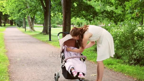 Mor med baby flicka i vagnen på sommaren park — Stockvideo