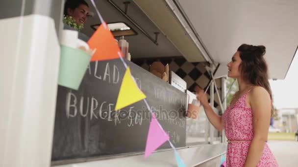 Mutlu genç kadın yemek yiyecek kamyonette sipariş — Stok video