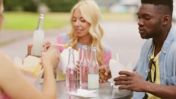 Друзья с едой звон напитков на открытом столе — стоковое видео