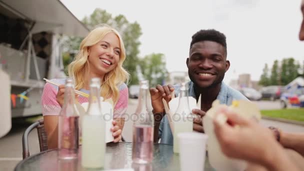 Přátelé s potravinami cinkání nápoje na venkovní stůl — Stock video