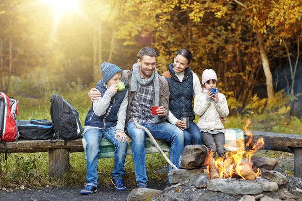 Šťastná rodina sedí na lavičce u táborového ohně — Stock fotografie