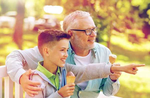Old man and boy eating ice cream at summer park — Stock Photo, Image