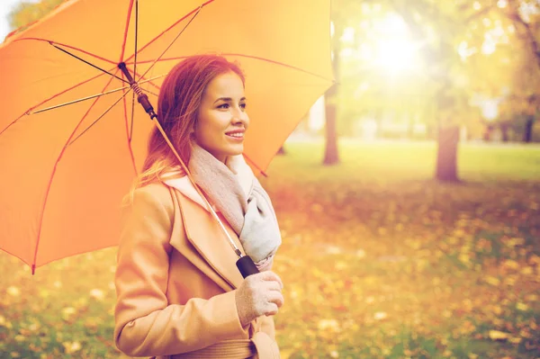 Donna felice con ombrellone passeggiando nel parco autunnale — Foto Stock