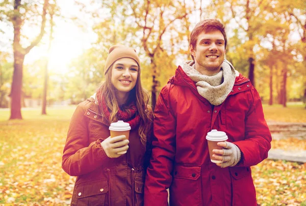 快乐的一对，带着咖啡在秋天的公园散步 — 图库照片