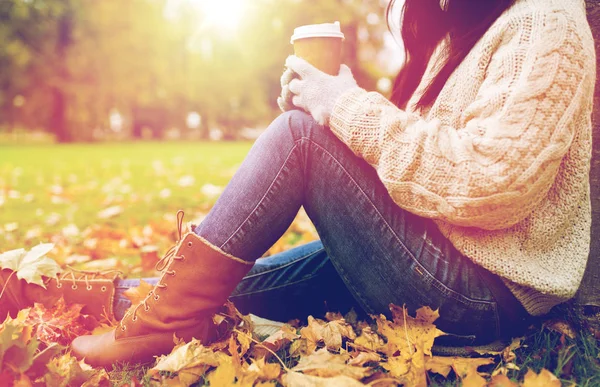 Close up of  woman drinking coffee in autumn park — Stock Photo, Image