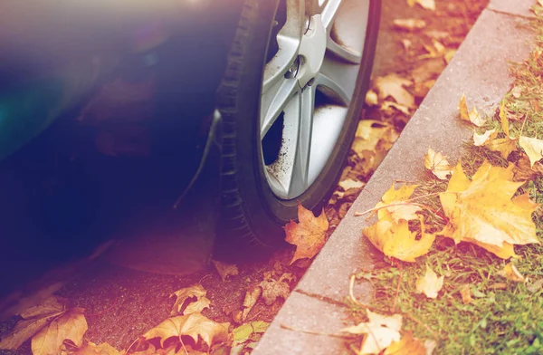 Detailní záběr kola automobilu a podzimní listí — Stock fotografie