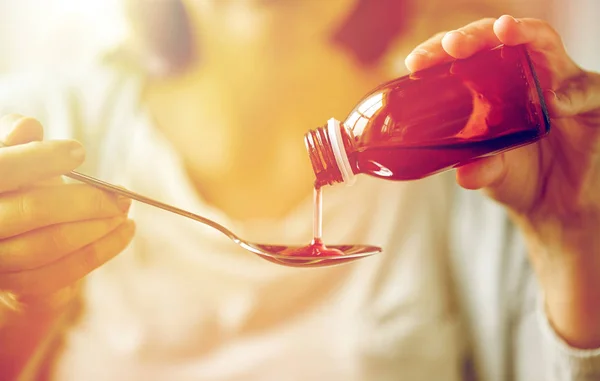Nő ömlött spoon palackból gyógyszeres kezelés — Stock Fotó
