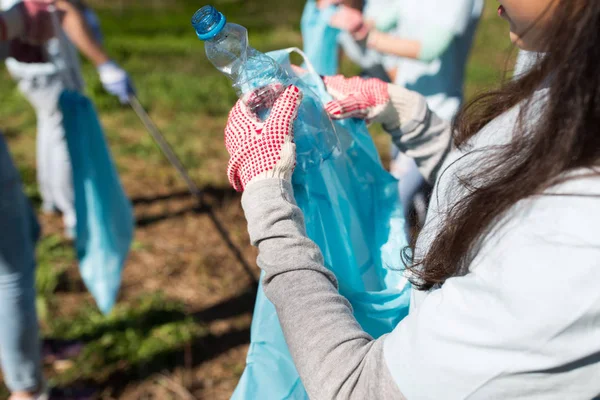 Relawan dengan kantong sampah dan area pembersihan botol — Stok Foto