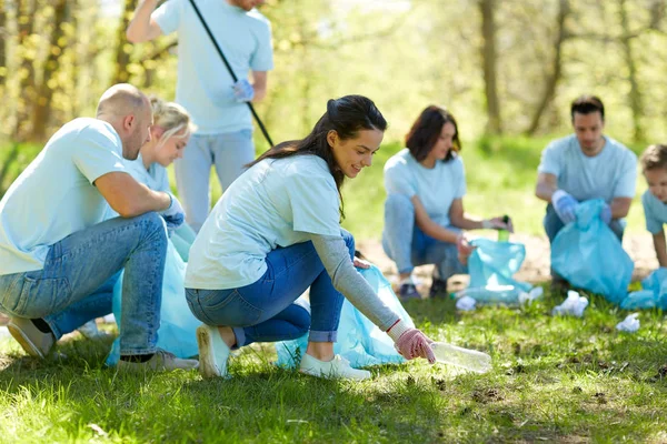 Voluntários com sacos de lixo área do parque de limpeza — Fotografia de Stock