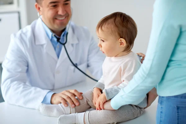 Médico com estetoscópio bebê escuta na clínica — Fotografia de Stock