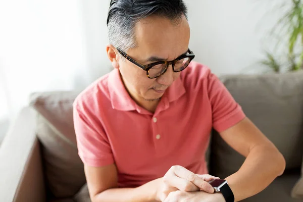 Close up van Aziatische man met slimme horloge thuis — Stockfoto