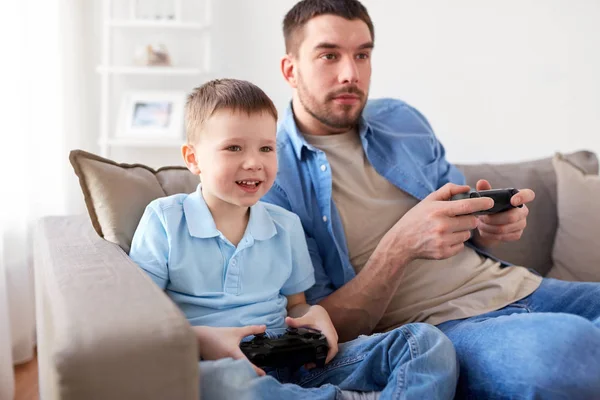 Padre e hijo jugando videojuegos en casa —  Fotos de Stock