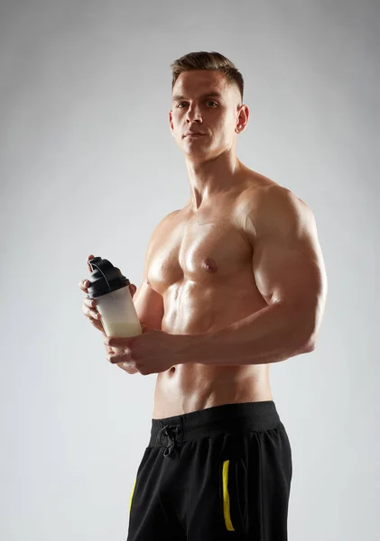 Giovane uomo o bodybuilder con bottiglia di frullato proteico — Foto Stock