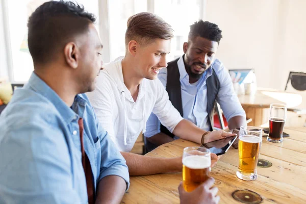 Amici maschi con tablet pc bere birra al bar — Foto Stock