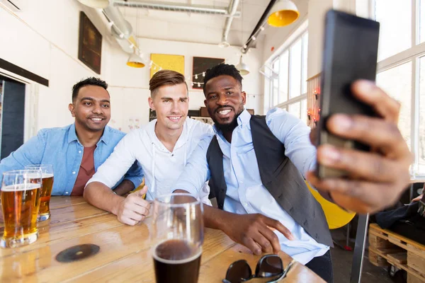 Amigos tomando selfie e beber cerveja no bar — Fotografia de Stock