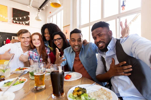 Amigos felices tomando selfie en restaurante o bar — Foto de Stock