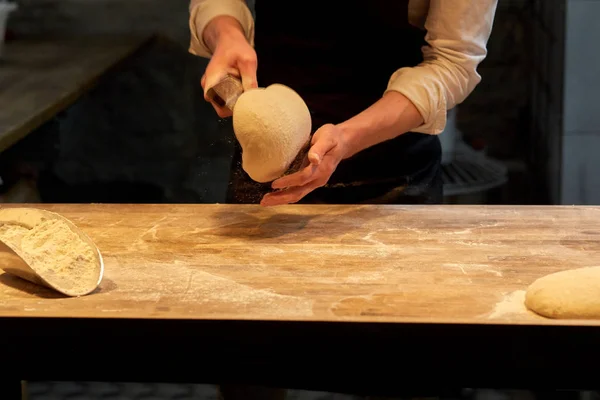 Baker portioning dough with bench cutter at bakery — Stock Photo, Image